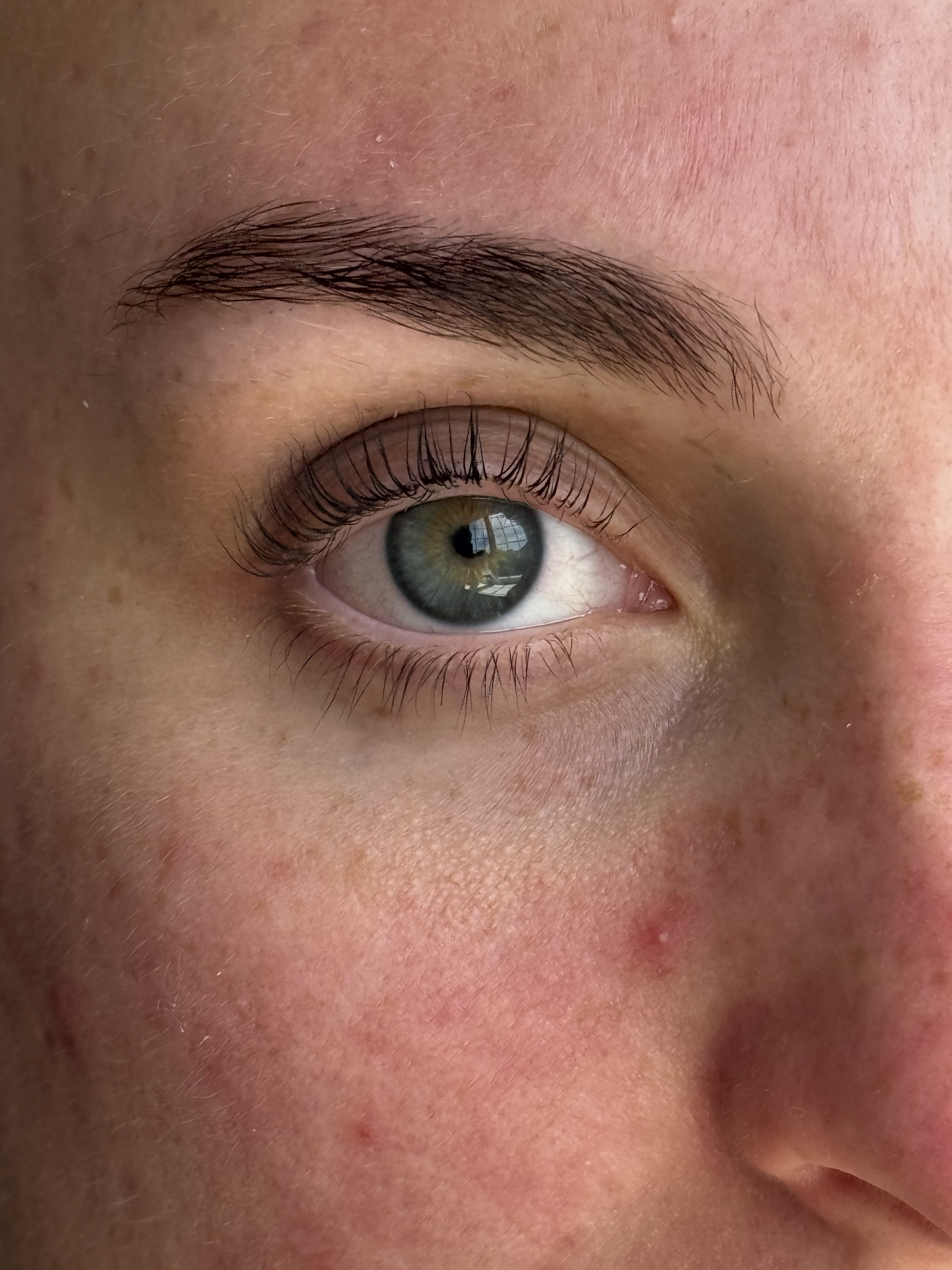 Extreme close-up of lash lift and tint result showing full, curled natural lashes